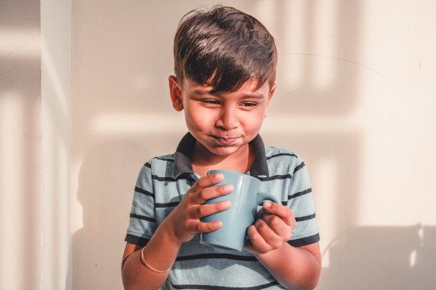 一个印度小男孩在他的手里玩着一个杯子图片下载