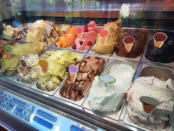 在希腊，一家冰淇淋店的门面上摆满了各种口味和颜色的冰淇淋图片下载