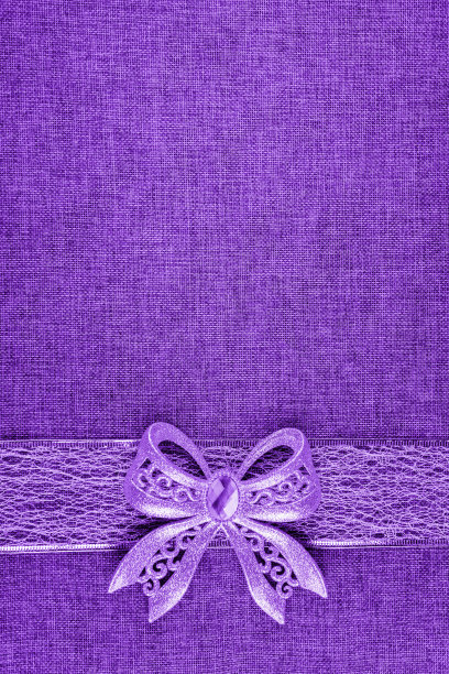 粗麻布上的紫色蝴蝶结和缎带。垂直的图像。图片下载