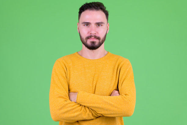 年轻英俊的胡子男人，双臂交叉图片下载