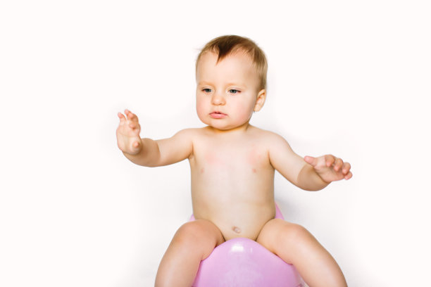 女婴坐在儿童盆上，白色背景上的马桶图片下载