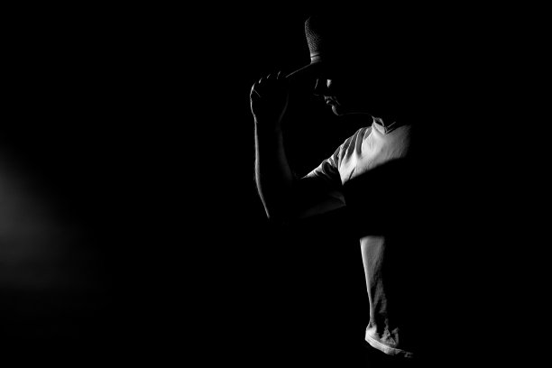 男人与帽子硬光轮廓在黑色的背景图片下载