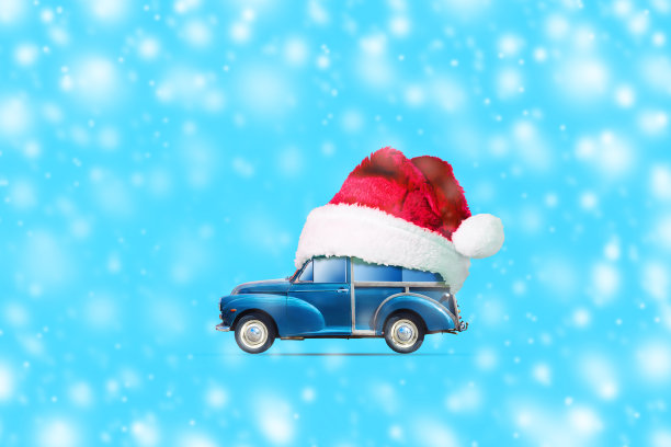 蓝色背景下圣诞老人帽子里的复古车。副本的空间。圣诞节。新年的背景。图片下载