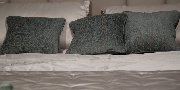 舒适的床上有柔软的枕头和米色的丝绸毯子图片下载