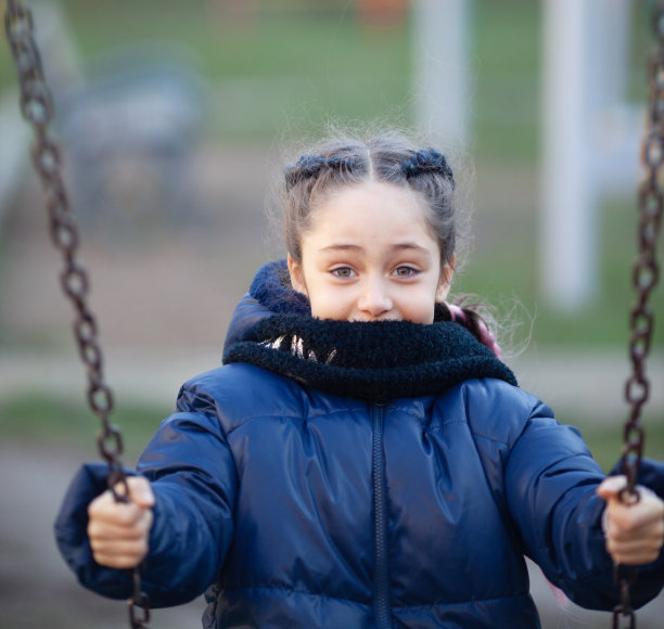 小女孩穿着冬衣在荡秋千图片下载