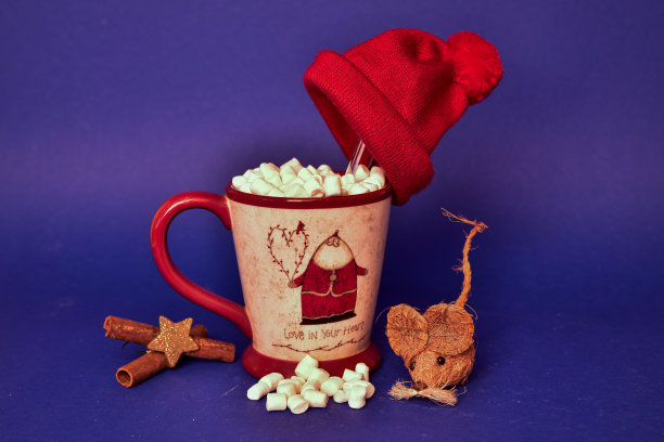 蓝色背景上放着一大杯咖啡，上面是圣诞老人的照片，里面是棉花糖图片下载