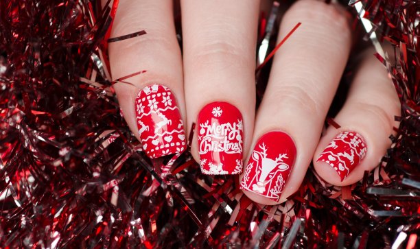 红色的圣诞美甲，点缀着鹿和雪花图片下载