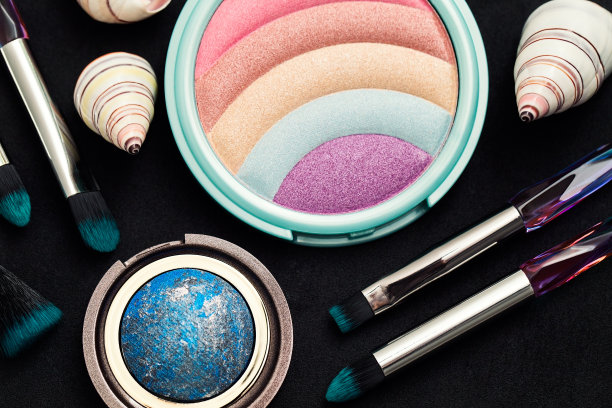 眼影调色板和化妆刷，腮红和彩虹色装饰在黑暗的背景图片下载