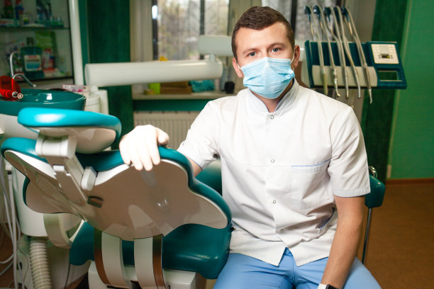 牙医戴着面具，医生坐在他的办公室里图片下载