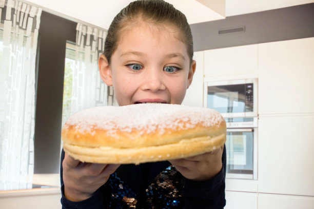 美丽的女孩站在一个巨大的tropezian派前图片下载