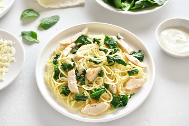 意大利面配菠菜叶、烤鸡胸肉片和碎乳酪图片下载