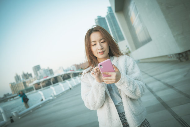 一名亚洲女性在公园里使用智能手机图片下载