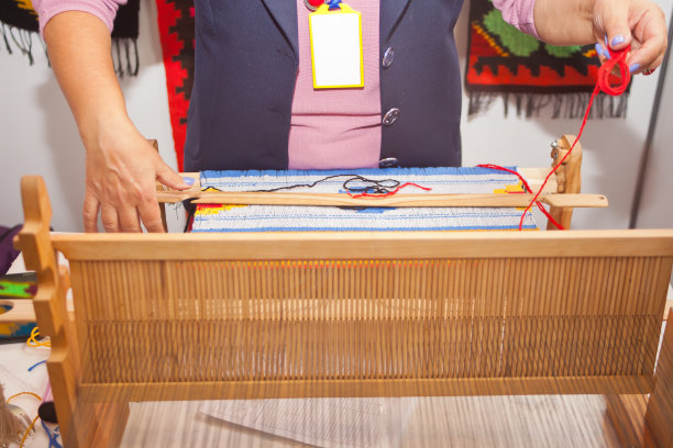 妇女在织布机上手工编织图片下载