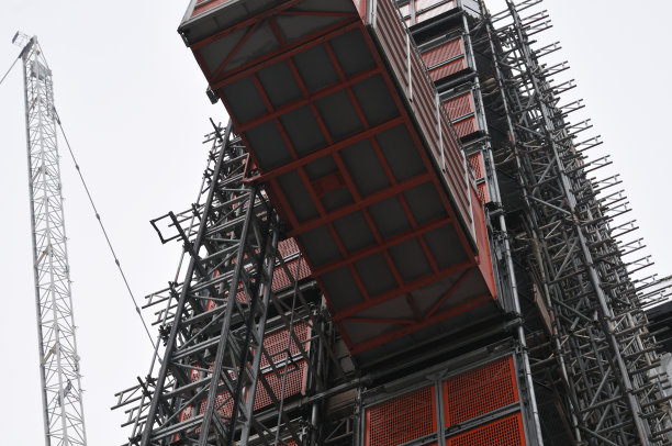 脚手架旁有金属电梯的建筑工地图片下载