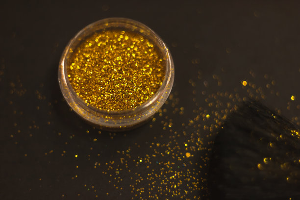 化妆刷和设计上的金色闪光纹理。在白色背景上。选择性聚焦-图像图片下载