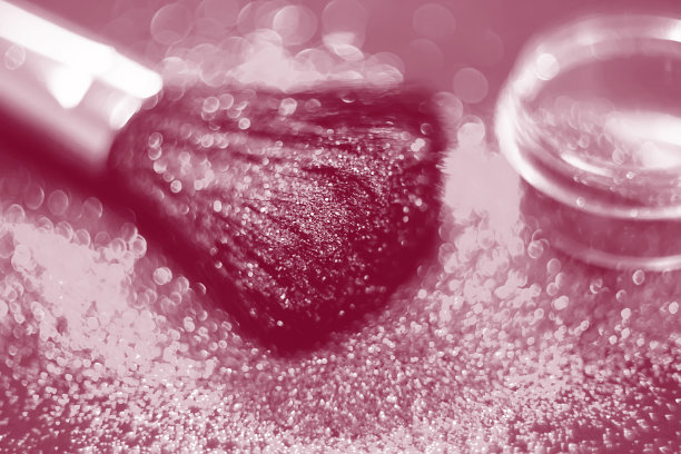 化妆刷和设计上的金色闪光纹理。在白色背景上。选择性聚焦-图像图片下载