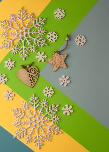 圣诞背景彩纸上有图案，有雪花、圣诞装饰品和木制玩具。图片下载