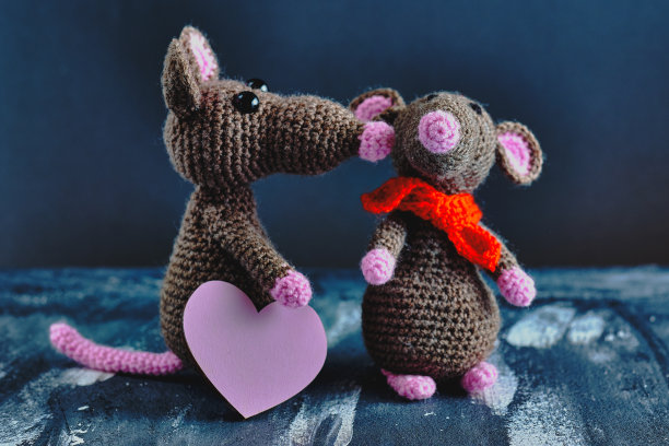 手制的粉心老鼠正在亲吻另一只玩具老鼠。蓝色背景。情人节，2月14日，爱情，关系概念。图片下载