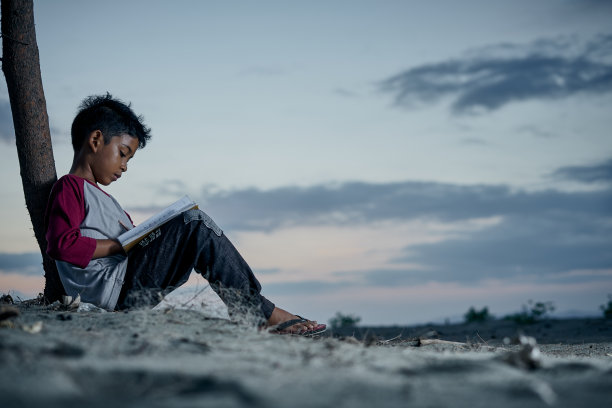 聪明的男孩晚上在天空下做作业图片下载