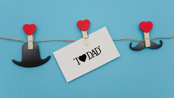 概念假日父亲节在一个蓝色的背景。亚麻花边上的衣夹夹住物体。图片下载