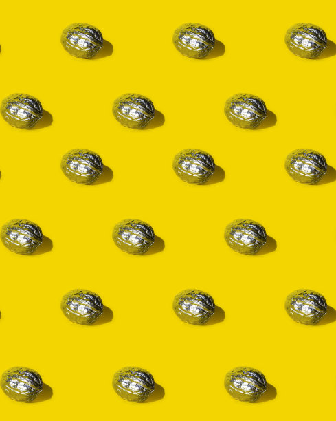 无缝图案与漆银核桃在黄色的背景。图片下载