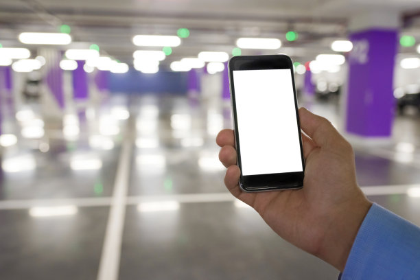 男子手持空白屏幕手机为您的文字或内容，在室内停车场。图片下载