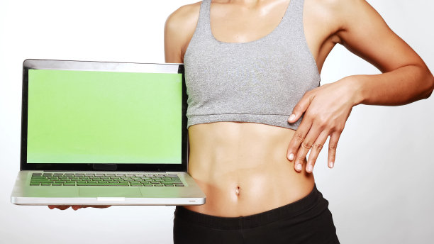 有魅力的女人站着，拿着笔记本电脑。图片下载