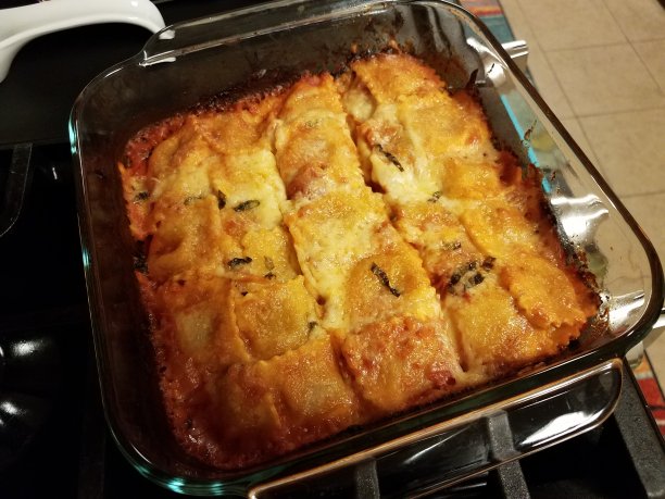 烤制的带奶酪的意大利饺子，放在炉子上的玻璃容器里图片下载