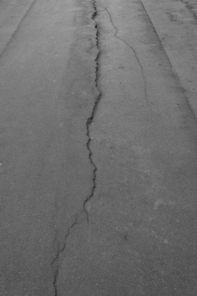 沥青道路。路面被破坏。黑白图像。图片下载