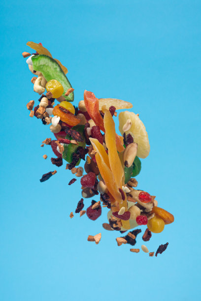 干果、蜜饯和坚果在蓝色背景上飞舞。健康和营养食物的库存照片。图片下载