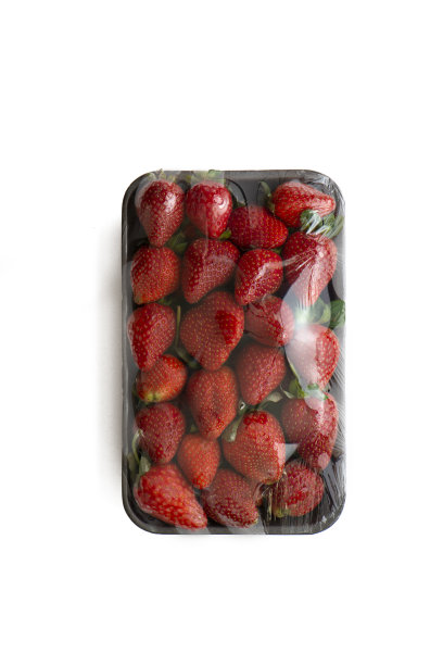 草莓装在塑料盒里放在石板板上，俯视图图片下载