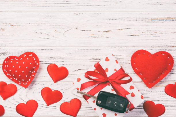 情人节或其他节日手工礼物在纸与红心，汽车钥匙和礼盒在节日包装。礼盒放在白色木质桌子上，顶部视有拷贝空间，空出空间进行设计图片下载