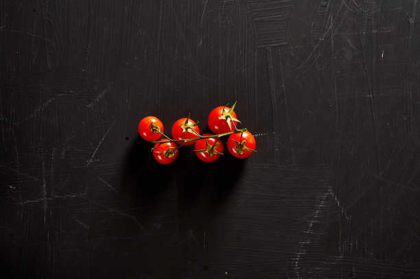 黑色背景上的樱桃番茄图片下载