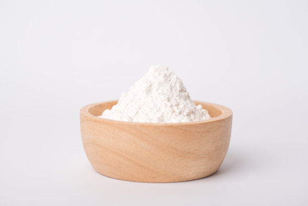 面粉放在一个棕色的木杯里，背景是白色图片下载