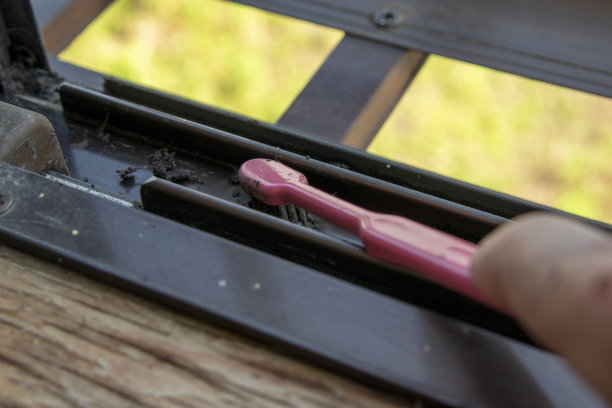 用粉红色的牙刷清洁窗框栏杆图片下载