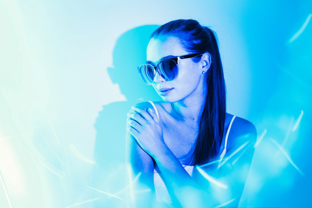 夜晚，一个穿着蓝色霓虹灯的女人的形象闪烁着。图片下载