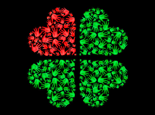 心形的绿色四瓣由手掌制成，象征着爱、幸运、自然保护和团聚，孤立在黑色背景上图片下载