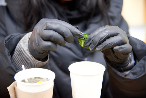 戴着无菌黑手套的妇女正在为泡茶制作薄荷。图片下载
