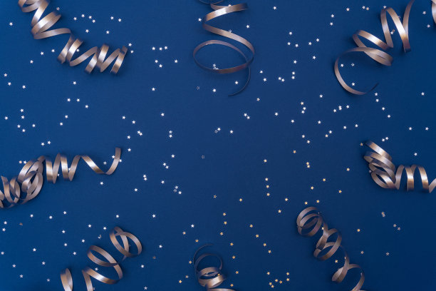 节日的组成与银色五彩纸屑和蛇纹石在时尚的经典蓝色背景。庆祝概念的想法为圣诞节，新年或任何其他节日。平铺，拷贝空间。有选择性的重点图片下载