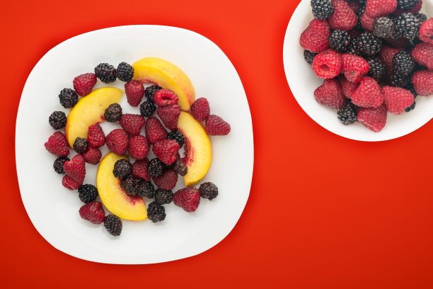 饮食,健康食品。黑莓、覆盆子、油桃放在盘子里的白色盘子里。素食食物的背景俯视图。图片下载