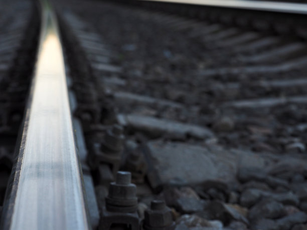 宏观铁路，铁轨和枕木延伸到日落的远处图片下载