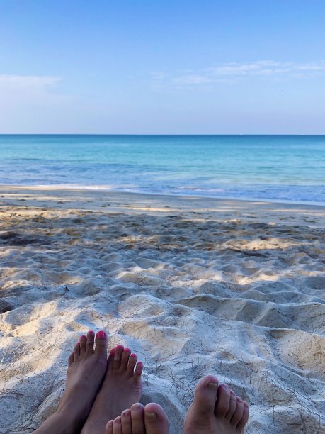 一张女性脚的照片，腿上的背景沙滩上的沙子图片下载