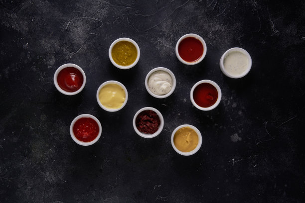 碗与美味的酱汁在黑色的乡村背景。俯视图图片下载