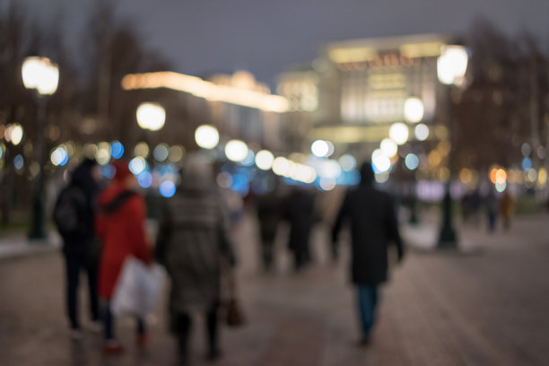 抽象模糊的背景，人们走在灯光照亮的城市在晚上图片下载