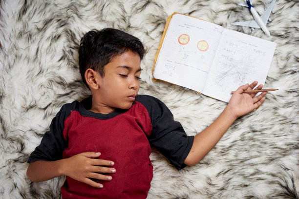 一个小学生在准备考试的时候睡着了图片下载