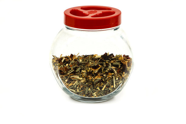 各种草药茶成分在一个玻璃罐孤立在一个白色的背景。白底玻璃罐中的花草茶。图片下载