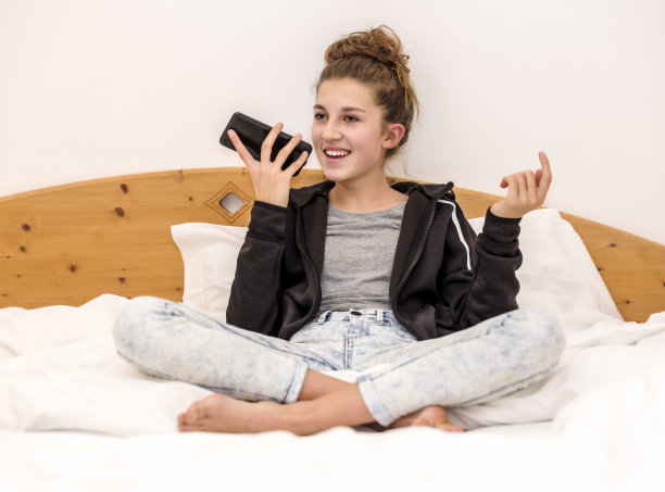 女孩在床上玩手机图片下载