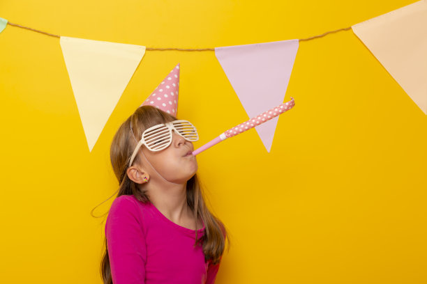 小女孩吹着派对的哨子图片下载