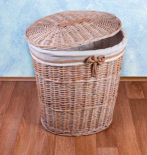 木制柳条洗衣篮，盖子半开放在地板上图片下载