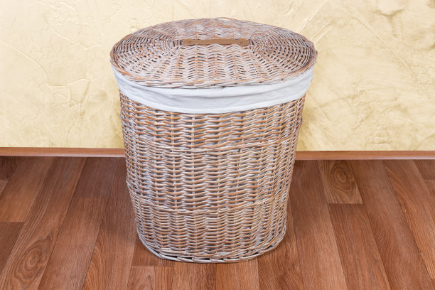 有盖子的柳条洗衣篮放在地板上图片下载